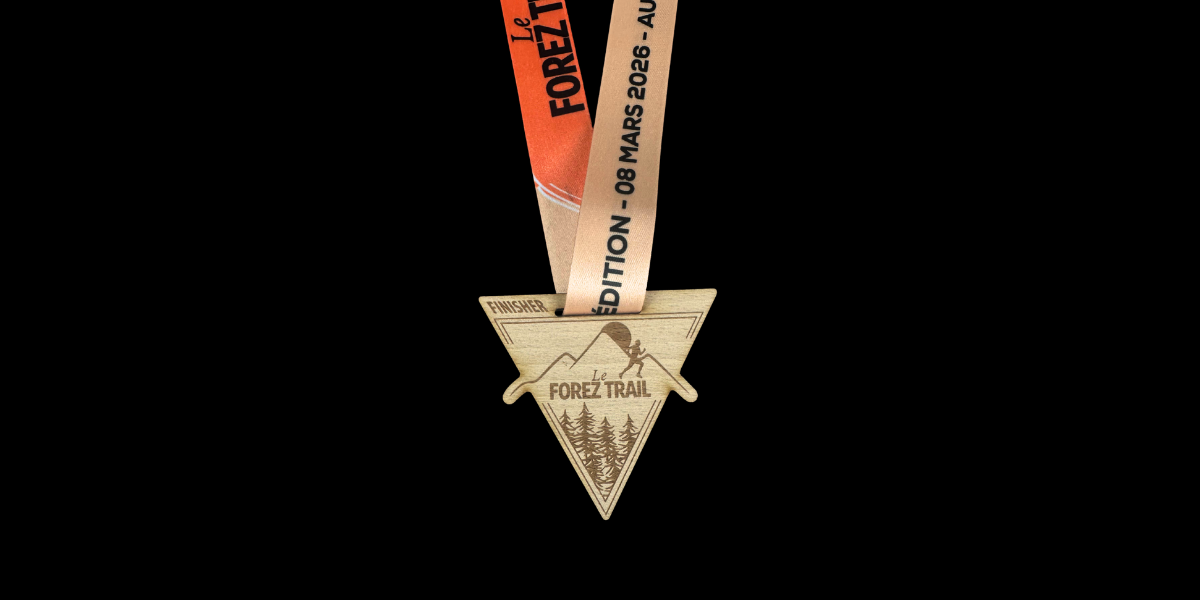 Médaille finisher en bois gravé en forme triangulaire pour Le Forez Trail 2026 avec ruban orange et beige personnalisé.